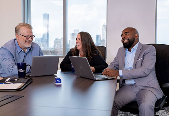 Three CSG consultants smiling in meeting