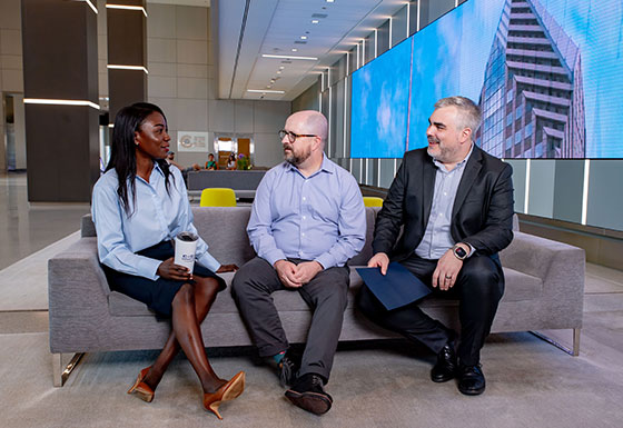 Three colleagues talking in office lobby